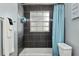 Tiled shower with glass block window and modern fixtures, complemented by a light blue shower curtain at 4851 Ne 7Th St, Ocala, FL 34470
