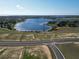 Scenic aerial view of a lake surrounded by new home construction in a planned community at 11057 Nellie Crossing Cir, Clermont, FL 34711