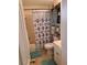 Cozy bathroom featuring a shower/tub combo with curtain, toilet, and built-in shelving at 11301 Huggins St, Leesburg, FL 34788