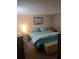Bedroom with coastal decor, including a bed with teal bedding and an ocean-themed art piece at 11301 Huggins St, Leesburg, FL 34788