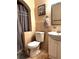 Bathroom featuring a toilet, sink, and shower with a gray curtain, offering a functional space at 14545 Sw 34Th Terrace Rd, Ocala, FL 34473