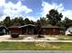 Exterior showing well-kept lawn and mature trees surrounding a charming house in a residential area at 14545 Sw 34Th Terrace Rd, Ocala, FL 34473