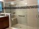 Modern bathroom with a tiled shower, a glass door, a built-in seat, and a grab bar at 803 Jasmine Creek Rd, Kissimmee, FL 34759