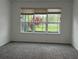 Sun-filled bedroom featuring a large window and neutral-colored carpeting at 803 Jasmine Creek Rd, Kissimmee, FL 34759