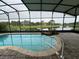 Enclosed pool with serene views of a lake, a golf course, and palm trees at 803 Jasmine Creek Rd, Kissimmee, FL 34759