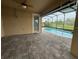 Covered pool deck with patterned pavers and views of a pool and golf course at 803 Jasmine Creek Rd, Kissimmee, FL 34759