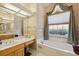 Bathroom with vanity and a garden tub under a draped window at 8929 Sw 196Th Ct, Dunnellon, FL 34432