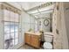 Well-lit bathroom featuring a door to the outside and a vanity at 8929 Sw 196Th Ct, Dunnellon, FL 34432