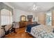 Primary bedroom featuring hardwood floors, a queen bed, and exercise bike near the windows at 8929 Sw 196Th Ct, Dunnellon, FL 34432