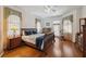 Bedroom with hardwood floors, a queen-size bed, and windows dressed with valances and curtains at 8929 Sw 196Th Ct, Dunnellon, FL 34432