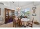 Cozy dining area with a floral tablecloth, china cabinet, and large window that provides an abundance of natural light at 8929 Sw 196Th Ct, Dunnellon, FL 34432