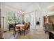 Elegant dining space with archway, chandelier, floral tablecloth, and abundant natural light from a large window at 8929 Sw 196Th Ct, Dunnellon, FL 34432