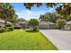 Traditional home with a well-maintained lawn and symmetrical curb appeal under a clear sky, showcasing a welcoming entryway at 8929 Sw 196Th Ct, Dunnellon, FL 34432