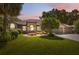 Charming home featuring a well-manicured lawn, lush landscaping, and a symmetrical facade enhanced by a colorful sunset sky at 8929 Sw 196Th Ct, Dunnellon, FL 34432