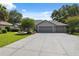 Suburban home with a wide driveway leading to an attached garage, set against a lush, green lawn at 8929 Sw 196Th Ct, Dunnellon, FL 34432