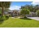 Well-maintained home featuring a lush front lawn, landscaped garden, and a spacious driveway leading to a three-car garage at 8929 Sw 196Th Ct, Dunnellon, FL 34432