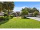 Charming one-story home featuring a lush green lawn, mature trees, and a well-maintained garden in front at 8929 Sw 196Th Ct, Dunnellon, FL 34432