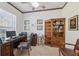 Cozy home office with dark wood desk, chair, bookcase, and a decorative border around the ceiling at 8929 Sw 196Th Ct, Dunnellon, FL 34432