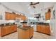 Bright kitchen featuring wood cabinets, granite countertops, white appliances, and a center island at 8929 Sw 196Th Ct, Dunnellon, FL 34432