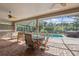 Relaxing screened-in patio features brick floors, ceiling fans, dining table, and views of the private pool at 8929 Sw 196Th Ct, Dunnellon, FL 34432