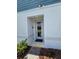 Entrance of a Hartizen Home with a glass front door, a welcome mat, and lush greenery at 1125 Red Buckeye Ct, Deland, FL 32720