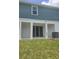The backyard has sliding glass door entrance and lawn at 1129 Red Buckeye Ct, Deland, FL 32720