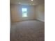 A spacious bedroom featuring neutral walls, plush carpet, and a window that offers lots of natural light at 1129 Red Buckeye Ct, Deland, FL 32720