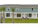 Backyard view of the townhome showing a patio, grass area and palm trees at 1133 Red Buckeye Ct, Deland, FL 32720