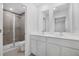 Bathroom featuring double sinks, white cabinetry, and a tiled walk-in shower at 1133 Red Buckeye Ct, Deland, FL 32720