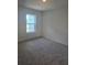 Carpeted bedroom with a window providing natural light, showcasing a simple and clean space at 1133 Red Buckeye Ct, Deland, FL 32720