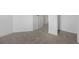 Carpeted bedroom with neutral colors and trim plus an electrical outlet on a white wall at 1133 Red Buckeye Ct, Deland, FL 32720