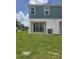 View of the backyard with sliding glass doors and green lawn at 1145 Red Buckeye Ct, Deland, FL 32720
