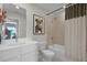 Bright bathroom with a single vanity, toilet and shower over tub with stylish tile and framed wall art at 1145 Red Buckeye Ct, Deland, FL 32720
