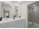 Modern bathroom featuring a double vanity with dual mirrors and a glass-enclosed shower at 1145 Red Buckeye Ct, Deland, FL 32720