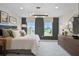 Inviting bedroom with a large bed, dresser, windows overlooking the outside and modern light fixture at 1145 Red Buckeye Ct, Deland, FL 32720