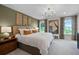 Serene bedroom featuring a plush bed, stylish chandelier, large windows and tasteful decor at 1145 Red Buckeye Ct, Deland, FL 32720
