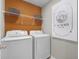 Bright laundry room with modern washer and dryer, complemented by stylish shelving and a decorative laundry sign at 1145 Red Buckeye Ct, Deland, FL 32720