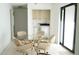 Dining area featuring a modern glass table with four upholstered chairs, with access to laundry room at 1315 Veech Rd, Leesburg, FL 34748