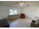 Bright living room with tile flooring, ceiling fan, and large window that provides ample natural light at 1315 Veech Rd, Leesburg, FL 34748