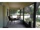 View of a screened-in porch with three chairs and a small table at 1315 Veech Rd, Leesburg, FL 34748