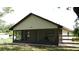 View of a screened-in porch with chairs, overlooking a grassy yard with trees at 1315 Veech Rd, Leesburg, FL 34748