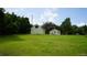 Spacious and well-maintained yard showcasing a home with a lush green lawn and mature trees at 1315 Veech Rd, Leesburg, FL 34748