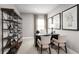 Well-lit home office featuring a desk, comfortable chairs, a bookshelf, and decorative accents with a serene window view at 1192 Ivy Manor St, Minneola, FL 34715