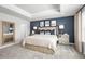 Well-lit bedroom boasts neutral carpet, and a striking navy accent wall, complemented by elegant decor at 6408 Domizio Dr, Winter Haven, FL 33884