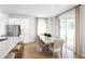 Dining area features a modern table set near the open kitchen with white cabinets and stainless steel appliances at 6408 Domizio Dr, Winter Haven, FL 33884