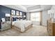 Bright main bedroom featuring a tray ceiling, accent wall, and large window at 6501 Domizio Dr, Winter Haven, FL 33884