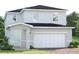 Charming two-story home with white siding, a covered entryway, and an attached two-car garage at 6505 Domizio Dr, Winter Haven, FL 33884