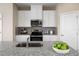 Modern kitchen with stainless steel appliances, granite countertops, and white cabinetry at 6505 Domizio Dr, Winter Haven, FL 33884