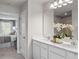 Bright bathroom with a double vanity, white cabinets, quartz countertop, and modern lighting fixtures at 6524 Domizio Dr, Winter Haven, FL 33884