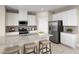 Modern kitchen with white cabinets, stainless steel appliances, granite countertops, and barstool seating at 6524 Domizio Dr, Winter Haven, FL 33884